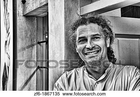Beautiful village of Oia withl local man standing in doorway in Santorini in Greek Islands in Greece Europe View Large Photo Image Stock Photography - Beautiful village of Oia withl local man standing in doorway in Santorini in Greek Islands in Greece Europe. Fotosearch