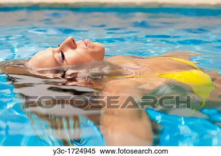 Beautiful woman in bikini enjoying a bath in a swimming pool View Large Photo Image Stock Photography - Beautiful woman in bikini enjoying a bath in a swimming pool. Fotosearch