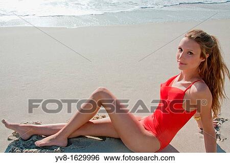 Beautiful woman laying on the beach in red swimsuit View Large Photo Image Stock Photograph - Beautiful woman laying on the beach in red swimsuit. Fotosearch