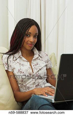 Beautiful young black woman using a laptop computer at home. View Large Photo Image Stock Photo - Beautiful young black woman using a laptop computer at home.. Fotosearch