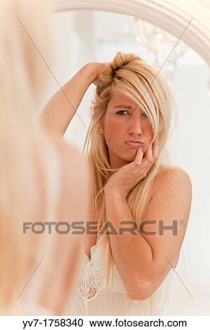 Beautiful young blonde looking in the mirror View Large Photo Image Stock Image - Beautiful young blonde looking in the mirror. Fotosearch