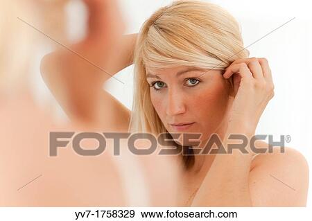 Beautiful young blonde preening in the mirror View Large Photo Image Stock Photo - Beautiful young blonde preening in the mirror. Fotosearch