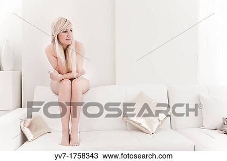 Beautiful young blonde sitting on the couch and looking out the window View Large Photo Image Stock Image - Beautiful young blonde sitting on the couch and looking out the window. Fotosearch