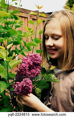 Stock Photography - Beautiful young girl with lilac flowers close up.. Fotosearch