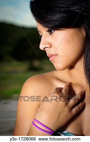 Stock Photograph - Beautiful young hispanic woman posing outdoors in summer dress. Fotosearch