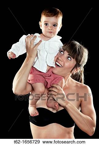 Stock Photo - Beautiful young mother playing with her child Beauty, caresses and tenderness Color. Fotosearch