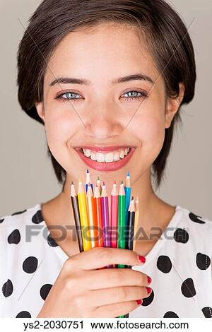 Beautiful young multiracial woman smiling and showing a set of colored pencils. 1015 View Large Photo Image Stock Image - Beautiful young multiracial woman smiling and showing a set of colored pencils. 1015. Fotosearch