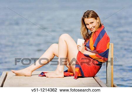 Beautiful young woman enjoying a coffee in a dock by the sea View Large Photo Image Stock Image - Beautiful young woman enjoying a coffee in a dock by the sea. Fotosearch