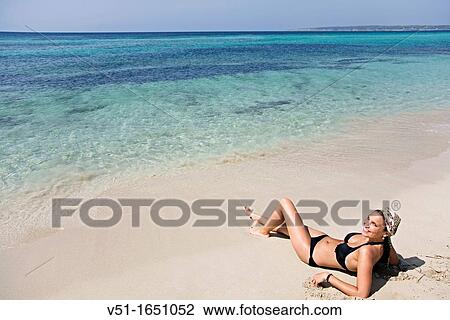Stock Image - Beautiful young woman enjoying a day at the beach in Formentera, Balearic Island, Spain. Fotosearch