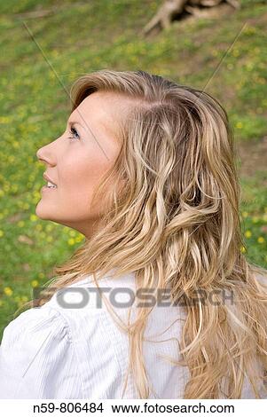 Beautiful young woman enjoying being outside in a green natural environment View Large Photo Image Picture - Beautiful young woman enjoying being outside in a green natural environment. Fotosearch
