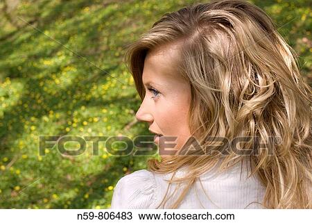 Stock Image - Beautiful young woman enjoying being outside in a green natural environment. Fotosearch