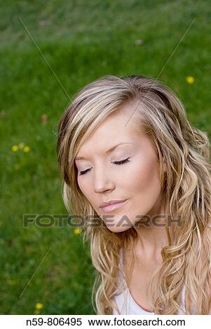 Beautiful young woman enjoying being outside in a green natural environment View Large Photo Image Stock Photography - Beautiful young woman enjoying being outside in a green natural environment. Fotosearch