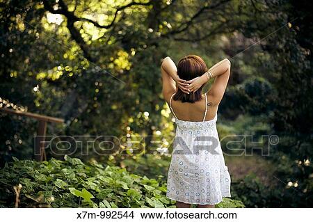 Picture - Beautiful young woman looking out into the forest. Fotosearch