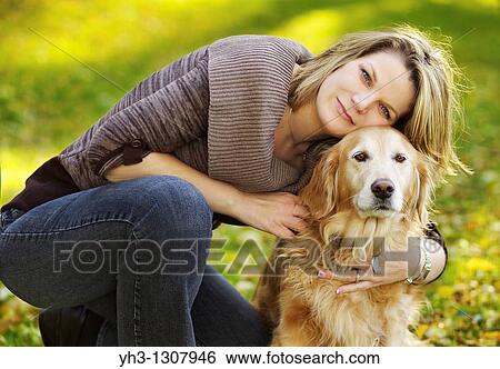 Beautiful young woman posing in front of the camera with her Golden Retriever dog, View Large Photo Image Stock Photograph - Beautiful young woman posing in front of the camera with her Golden Retriever dog,. Fotosearch