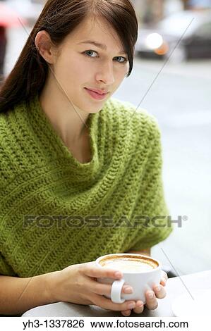 Beautiful young woman relaxing with her cappuccino outdoor View Large Photo Image Stock Photograph - Beautiful young woman relaxing with her cappuccino outdoor. Fotosearch