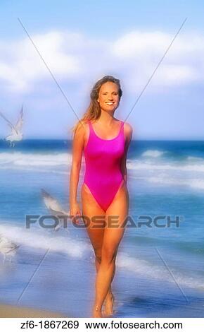 Beautiful young woman walking on the beach View Large Photo Image Stock Photo - Beautiful young woman walking on the beach. Fotosearch
