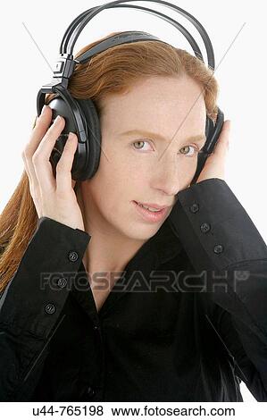 Stock Photo - Beautifull woman hearing music on wired headphones. Fotosearch