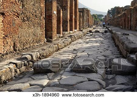 Stock Image - Because of the perpetually flowing water, stepping stones were required to cross the streets and keep the way for carts, archeological site of Pompeii, province of Naples, Campania region, southern Italy, Europe. Fotosearch