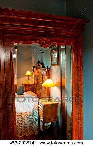 Stock Image - Bedroom reflected on the mirror of a wardrobe.. Fotosearch
