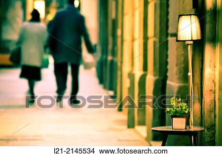 Bedside lamp and bedside table on a street. Blurred couple walking along a street. Barcelona, Catalonia, Spain. View Large Photo Image Picture - Bedside lamp and bedside table on a street. Blurred couple walking along a street. Barcelona, Catalonia, Spain.. Fotosearch