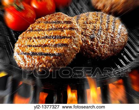 Beef burgers being cooked in a skillet with flames. View Large Photo Image Stock Photo - Beef burgers being cooked in a skillet with flames.. Fotosearch