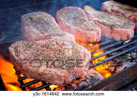 Beef Ribeye Steaks grilling over hot fire View Large Photo Image Stock Image - Beef Ribeye Steaks grilling over hot fire. Fotosearch