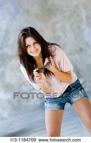 Bend with sunglasses in hands smiling young woman View Large Photo Image Stock Photo - Bend with sunglasses in hands smiling young woman. Fotosearch