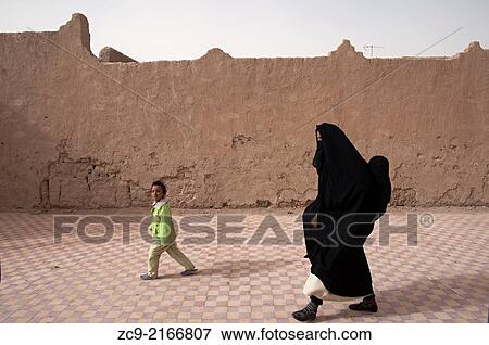 Berber woman in traditional moroccan niqab walking on the street with her little daughter, Rissani, Ziz Valley, Morocco. View Large Photo Image Stock Photo - Berber woman in traditional moroccan niqab walking on the street with her little daughter, Rissani, Ziz Valley, Morocco.. Fotosearch
