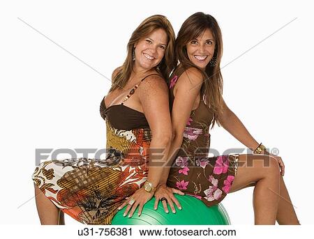 Best friends in her 40s sitting on an exercise ball smiling at the camera View Large Photo Image Stock Image - Best friends in her 40s sitting on an exercise ball smiling at the camera. Fotosearch