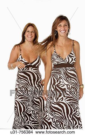 Picture - Best friends in their early 40s wearing exactly the same dress. Fotosearch