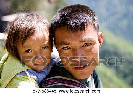Stock Photography - Bhutan. Paro. Bhutanese man with daughter.. Fotosearch