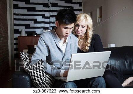 Bi-racial couple with a laptop View Large Photo Image Stock Image - Bi-racial couple with a laptop. Fotosearch