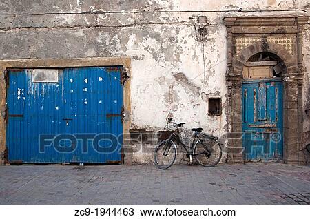 Bicycle parked next to a blue moroccan door, Essaouira medina, Morocco. View Large Photo Image Stock Image - Bicycle parked next to a blue moroccan door, Essaouira medina, Morocco.. Fotosearch