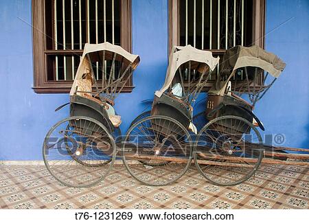 Stock Photo - bicycle rickshaws in front of the Cheong Fatt Tze Chinese Mansion in Georgetown, Malaysia. Fotosearch
