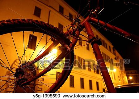 Stock Image - bike in road street at night in rome italy.. Fotosearch