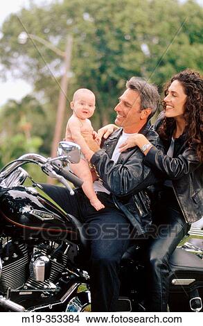 Picture - biker couple with baby. Fotosearch