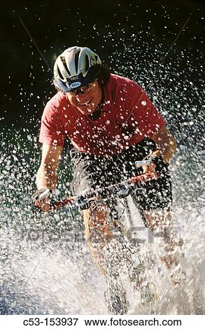 Biking through stream View Large Photo Image Stock Photo - Biking through stream. Fotosearch
