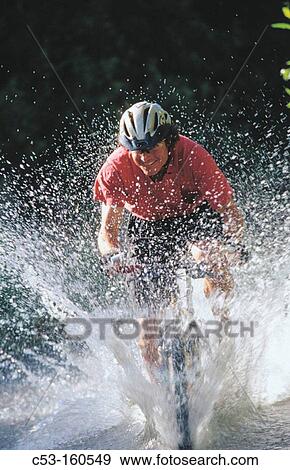 Stock Photo - Biking through stream. Fotosearch