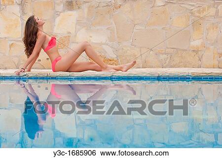 Stock Photograph - Bikini girl posing at swimming pool. Fotosearch