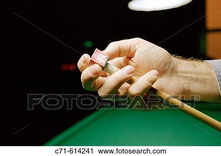 Stock Image - Billiards game, applying chalk to the cue tip. Fotosearch