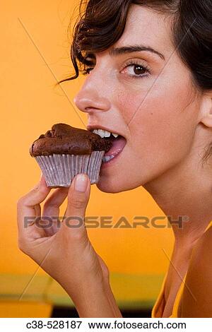 Biting a Chocolate Muffin View Large Photo Image Stock Photo - Biting a Chocolate Muffin. Fotosearch