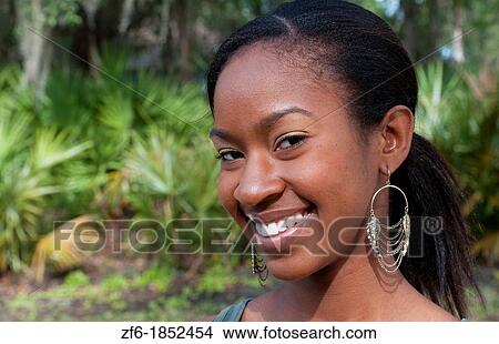 Black African American girl aged 18 portrait in yard outdoors laughing View Large Photo Image Picture - Black African American girl aged 18 portrait in yard outdoors laughing. Fotosearch