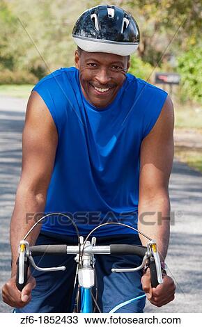 Black african american man in 40s dressed in sports wear on bike exercising in park with no business stress View Large Photo Image Stock Image - Black african american man in 40s dressed in sports wear on bike exercising in park with no business stress. Fotosearch