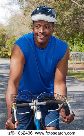 Black african american man in 40s dressed in sports wear on bike exercising in park with no business stress View Large Photo Image Stock Photograph - Black african american man in 40s dressed in sports wear on bike exercising in park with no business stress. Fotosearch