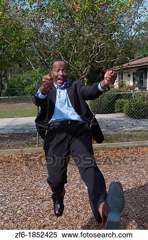 Black african american man in 40s dressed in business suit having so much fun on swing in park with no business stress View Large Photo Image Stock Photography - Black african american man in 40s dressed in business suit having so much fun on swing in park with no business stress. Fotosearch