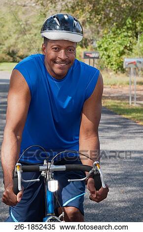 Black african american man in 40s dressed in sports wear on bike exercising in park with no business stress View Large Photo Image Stock Photography - Black african american man in 40s dressed in sports wear on bike exercising in park with no business stress. Fotosearch