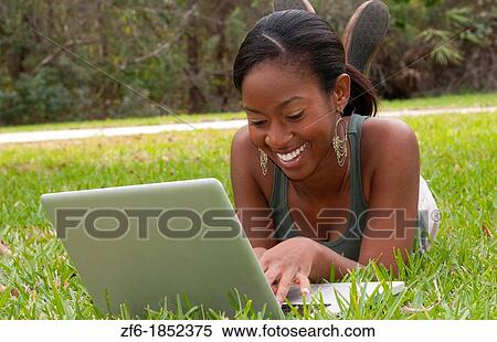 Black African American teen girl age 18 working on computer facebook with emailing friends in front yard on grass View Large Photo Image Stock Photography - Black African American teen girl age 18 working on computer facebook with emailing friends in front yard on grass. Fotosearch
