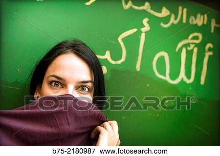 Black hair young woman looking at the camera against a wall with graffiti and covering his face with a pamina in the Medina of Fez, Morocco, Africa. View Large Photo Image Stock Photo - Black hair young woman looking at the camera against a wall with graffiti and covering his face with a pamina in the Medina of Fez, Morocco, Africa.. Fotosearch