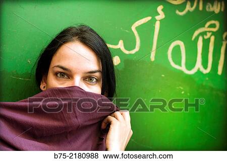 Black hair young woman looking at the camera against a wall with graffiti and covering his face with a pamina in the Medina of Fez, Morocco, Africa. View Large Photo Image Stock Photo - Black hair young woman looking at the camera against a wall with graffiti and covering his face with a pamina in the Medina of Fez, Morocco, Africa.. Fotosearch