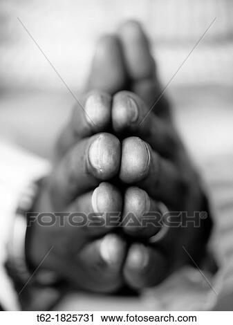 Stock Image - Black hands praying Black and White Vertical. Fotosearch